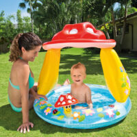 Bambino in piscina gonfiabile con mamma in giardino